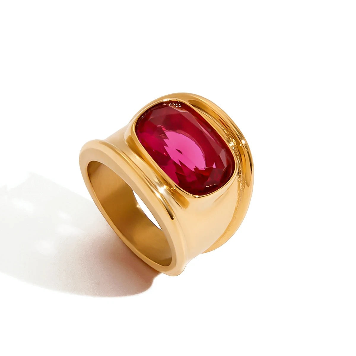 Gold ring with a red gemstone on a white background