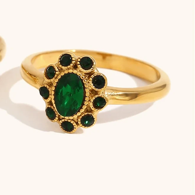 Gold ring with green gemstone on a white background
