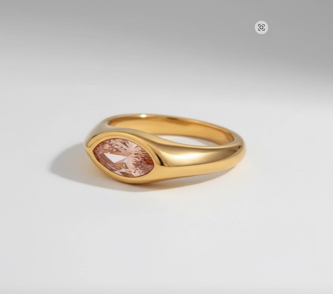 Gold ring with a pink gemstone on a white background