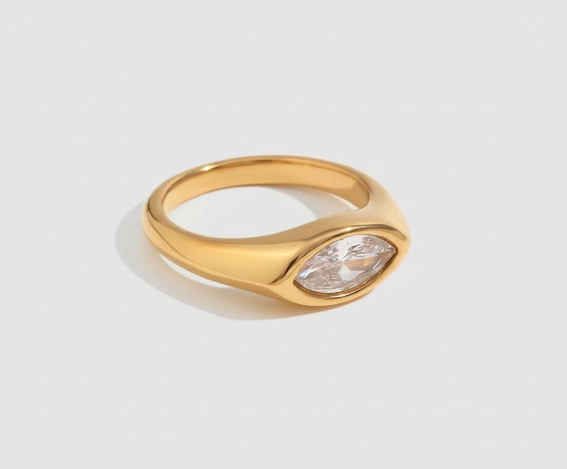 Gold ring with a diamond on a light gray background